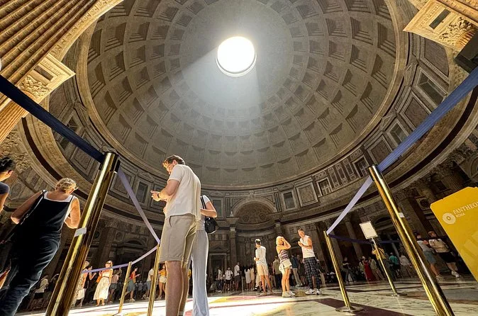 Visitors standing under the oculus as light falls into the rotunda