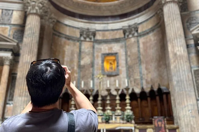 A visitor photographing an altar in one of the Pantheon's side chapels