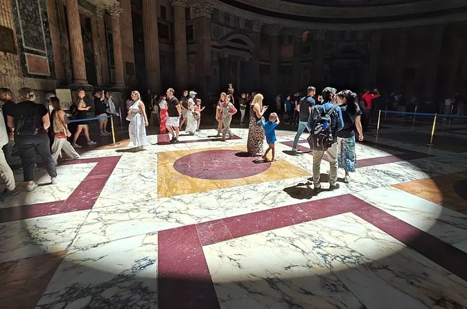 A disc of sunlight from the oculus lying on the coloured marble floor of the Pantheon